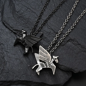 Origami Pegasus necklaces in black and vintage silver on dark textured rock surface