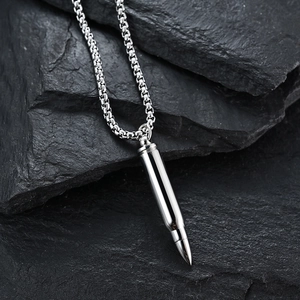Polished silver stainless steel bullet pendant necklace on a textured stone background
