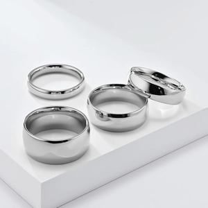 Detail view of four silver stainless steel rings in varying widths with polished finish