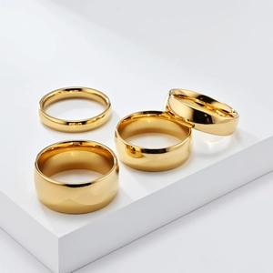 Polished gold titanium steel rings in four different widths on white stone steps
