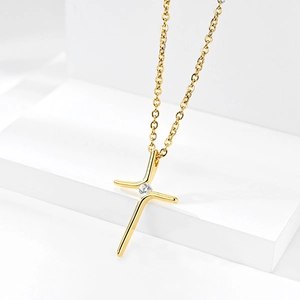Elegant 18K gold plated cross necklace with zircon stone on minimalist white backdrop
