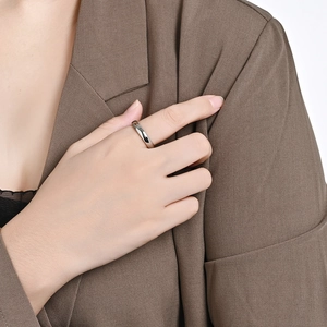 Close-up of a minimalist silver stainless steel ring on finger with professional office style