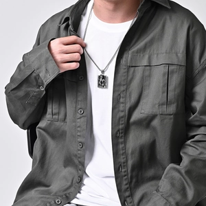 Vintage relief pendant necklace in silver stainless steel for men shown on a male model