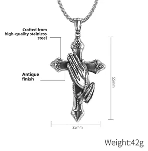 Macro detail of retro praying hands cross pendant in steel with dimensions 55mm by 35mm