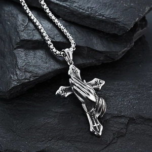 Gothic vintage stainless steel praying hands cross necklace on textured stone