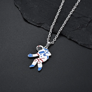 Detailed view of a white enamel astronaut pendant with blue and red lines on black stone
