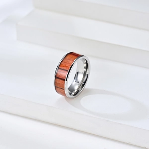 Macro view of minimalist stainless steel ring with natural reddish wood inlay detail