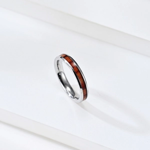 Polished stainless steel ring with dark wood inlay shown on a white pedestal
