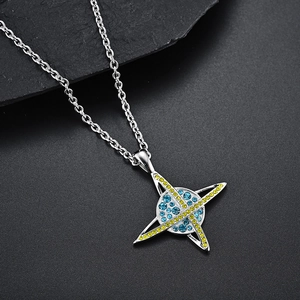 Vue macro du pendentif planète avec strass bleus et jaunes et fine chaîne argentée