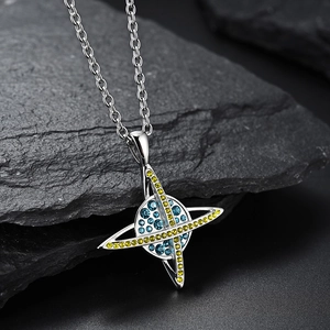 Collier pendentif planète argentée avec cristaux bleus et jaunes sur un fond de roche
