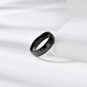Macro detail of black faceted zirconia ceramic ring with geometric beveled edges
