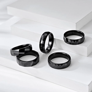 Minimalist black ceramic ring set with geometric multi-faceted diamond cut surface