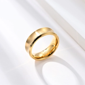 Minimalist matte gold brushed stainless steel ring on a white geometric background