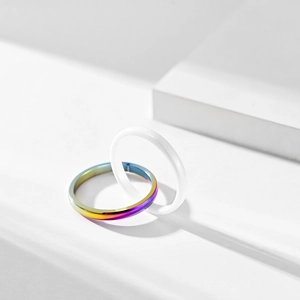 Detail von ineinandergreifenden Ringen aus weißer Keramik und Regenbogenstahl