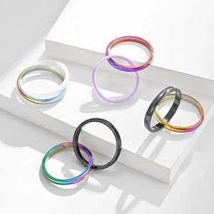 Minimalistische Scharnierringe aus Edelstahl in mehreren Farben auf weißen Geometriestufen
