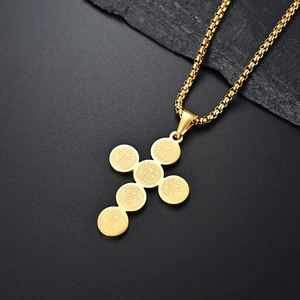 Collana a croce con medaglia di San Benedetto dorata e catena box su sfondo di ardesia