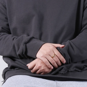 Vue détaillée d'une bague dorée à motifs étoilés portée par un mannequin en style urbain