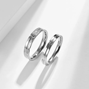 Detail von Paarringen mit LOVE NEVER FAILS Gravur und kleinen runden Zirkonia-Steinen