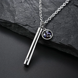 Macro d'un pendentif flacon de parfum avec breloque nébuleuse sur pierre noire