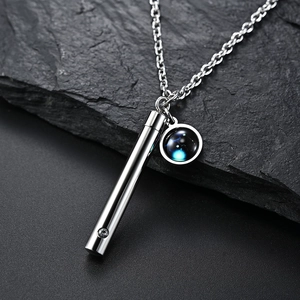 Détail macro du collier pendentif flacon de parfum zodiaque lumineux en acier inoxydable