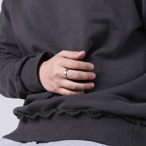 Polierter silberner Edelstahl-Ehering mit kleinem Diamanten an der Hand eines Modells