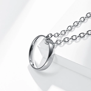 Macro shot of polished S925 sterling silver ring pendant necklace on white stand