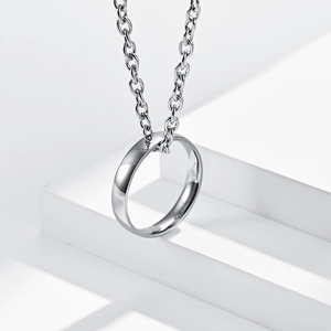 Macro detail of silver titanium steel ring pendant hanging on a thick metal chain
