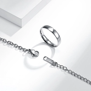 Polished silver K14 engraved titanium steel ring and chain necklace on white pedestal