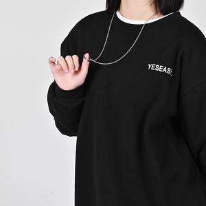 Minimalist silver ring and chain necklace styled on a black sweatshirt outfit