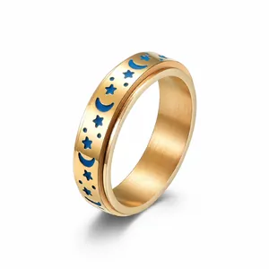 Detail view of 6mm spinner ring featuring blue enamel moon and star pattern over gold finish