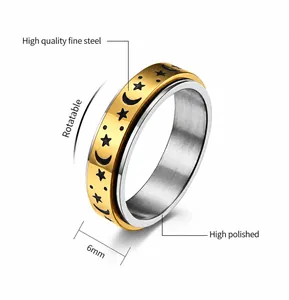 Detail view of 6mm spinner ring featuring black star and moon motifs on a gold band