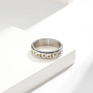 Macro detail of rotating stainless steel ring with golden star and moon patterns