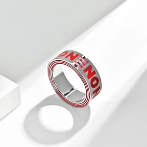 Gros plan d'une bague hip-hop en acier argenté avec texte NON en émail rouge et rayures