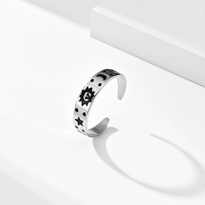 Détail d'une bague argentée ajustable avec motifs gravés de soleil, lune et étoiles