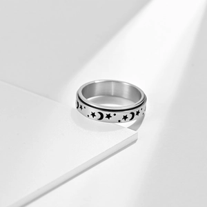 Detailed view of rotating star and moon patterns on a brushed stainless steel anxiety ring