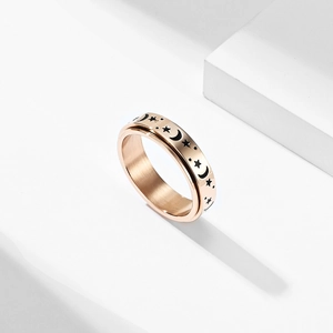 Detail of rose gold spinner ring with engraved star and moon anxiety relief design