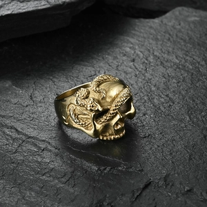 Macro shot of gold hip-hop ring featuring realistic skull and coiled snake scales detail