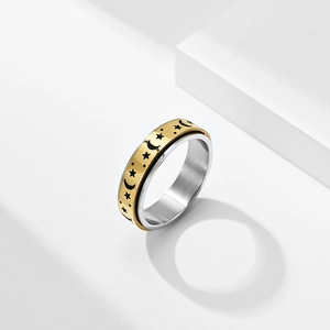 Close-up of golden spinning ring with moon and stars engravings on stainless steel band
