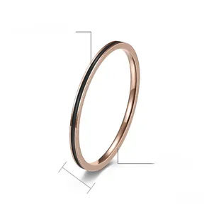 Détail d'une bague fine en acier or rose de 1,2 mm avec émail noir goutte