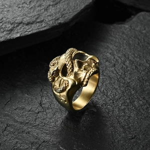 Detail of gothic gold skull and snake ring showing intricate scales and textures