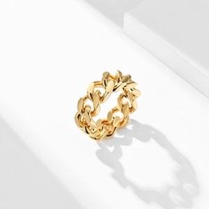 Makro-Detail eines hochglanzpolierten goldenen Panzerketten-Rings auf weißem Grund