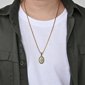Detail of Saint Christopher gold pendant with embossed figure on a classic box chain