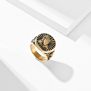 Golden stainless steel signet ring with praying hands relief on a white pedestal