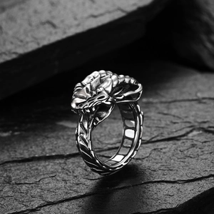 Macro detail of gothic dragon ring showing intricate metal scales and monster head carving