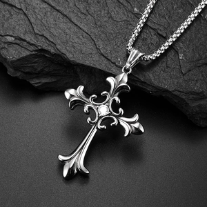 Collier croix vintage en acier inoxydable avec zircon central brillant sur une roche