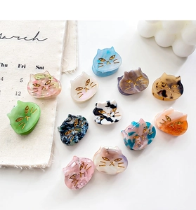 Detailed macro view of cat-shaped acetate hair claws with various marble textures