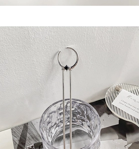 Macro shot of silver crescent moon hair pin with black square gemstone in glass