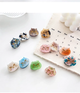 Close-up of marble pattern acetate cat hair clips in various pastel colors
