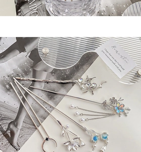 Close-up of silver metal hairpins with moonstone tassels and refined floral details