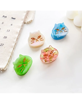 Detailed close-up of colorful cat-shaped acetate hair claws in four elegant textures